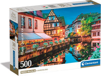 Caja del puzzle Casco Antiguo de Estrasburgo de 500 piezas de Clementoni, con casas de entramado de madera junto al canal reflejadas en el agua al anochecer