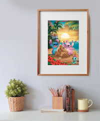 Puzzle Disney Stitch 500 piezas Clementoni montado y enmarcado en madera sobre una pared, con la escena de Stitch y Angel en la playa; debajo, una planta, un bote de lápices, libros y una taza.