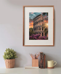 Puzzle Anfiteatro 500 piezas Clementoni montado y enmarcado en madera sobre una pared, con la escena del Coliseo de Roma al atardecer; debajo, una planta, un bote de lápices, libros y una taza.