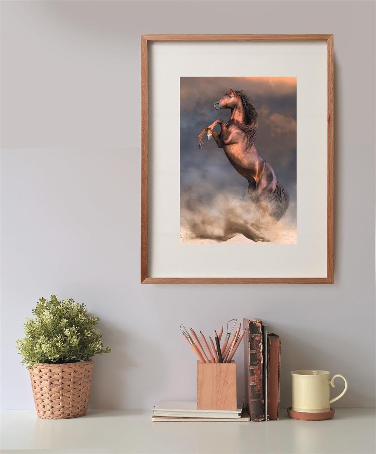 Puzzle Caballo Rojo Salvaje 500 piezas Clementoni montado y enmarcado en madera sobre una pared, con la escena del caballo rojizo encabritado entre polvo; debajo, una planta, un bote de lápices, libros y una taza.