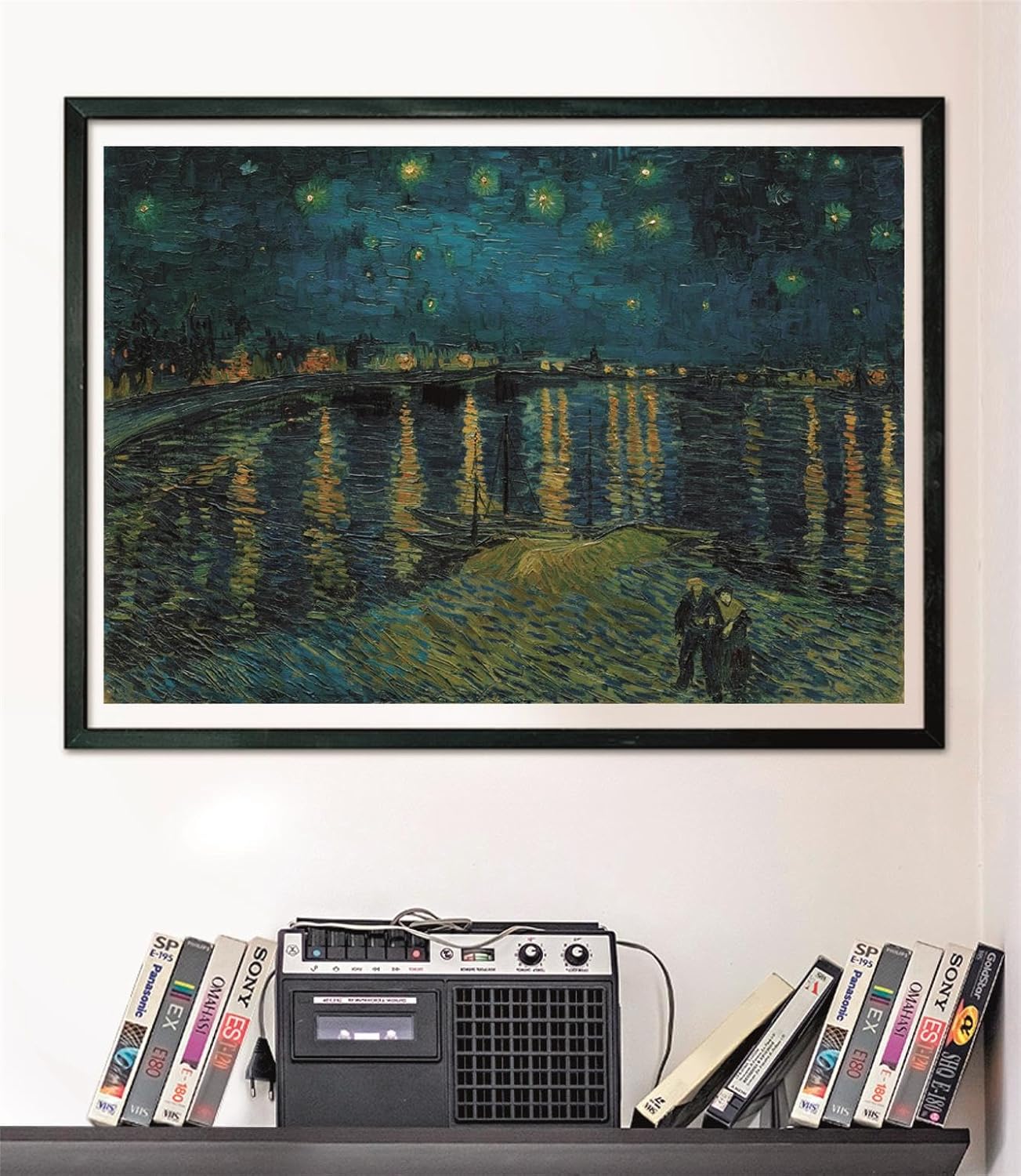 Puzzle La Noche Estrellada sobre el Ródano Van Gogh 1000 piezas Clementoni Museum Collection montado y enmarcado en negro sobre pared, sobre un estante con cintas VHS y radio-casete vintage