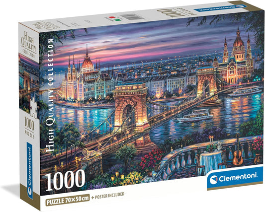 Caja del Puzzle Paisaje Nocturno de Budapest 1000 piezas Clementoni. Pintura del Puente de las Cadenas sobre el Danubio al anochecer, con el Parlamento iluminado y una mesa con guitarra en primer plano.