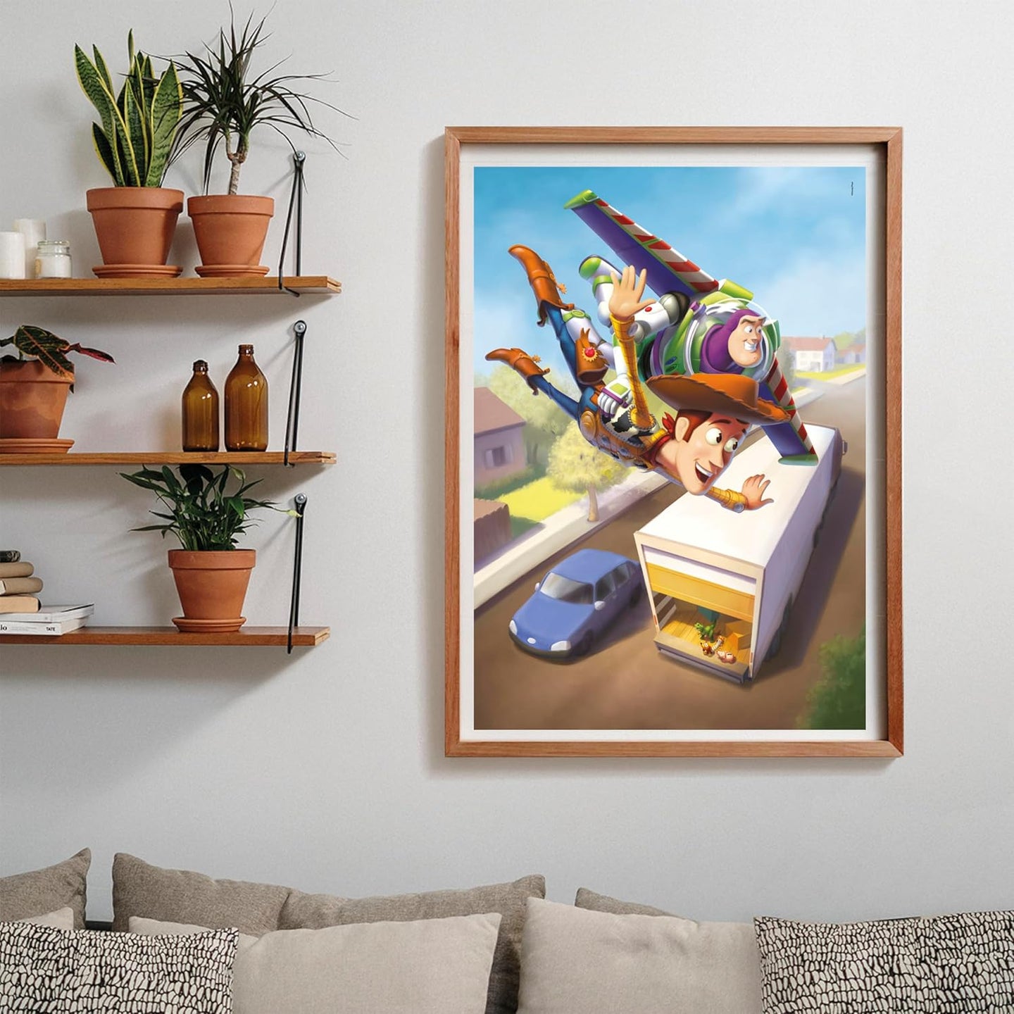 Puzzle Toy Story 1000 piezas Clementoni montado y enmarcado en madera sobre una pared, con la escena de Woody y Buzz volando sobre el camión; al lado, estantes con plantas y libros, y debajo un sofá con cojines.