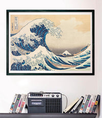 Puzzle La Gran Ola de Hokusai 1000 piezas Clementoni Museum Collection montado y enmarcado en negro sobre pared, sobre un estante con cintas VHS y radio-casete vintage