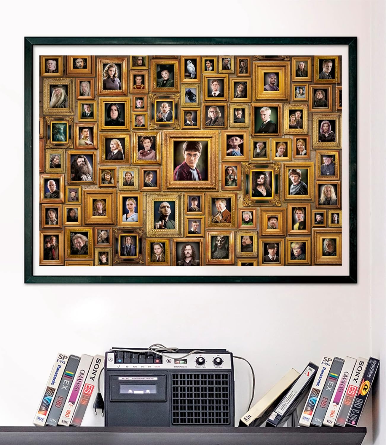 Puzzle Harry Potter Retratos 1000 piezas Clementoni montado y enmarcado en negro sobre una pared, con la pared de marcos dorados y los personajes de la saga; debajo, un radiocasete y cintas VHS en una estantería.