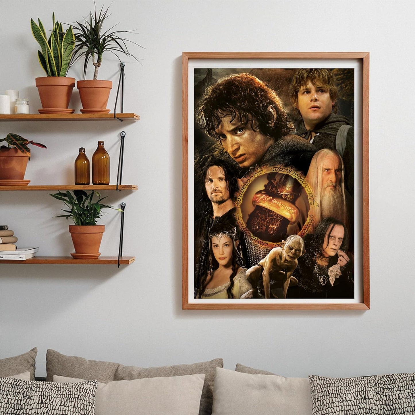Puzzle El Señor de los Anillos 1000 piezas Clementoni montado y enmarcado en madera sobre una pared, con el collage de personajes de la película; al lado, estantes con plantas y libros, y debajo un sofá con cojines.