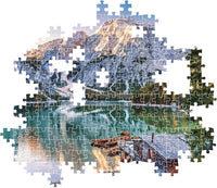 Montaje parcial del puzzle Lago Esmeralda 1000 piezas Clementoni con piezas sueltas mostrando el lago, las montañas y la cabaña