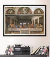 Puzzle La Última Cena de Leonardo 1000 piezas Clementoni Museum Collection montado y enmarcado en negro sobre pared, sobre un estante con cintas VHS y radio-casete vintage