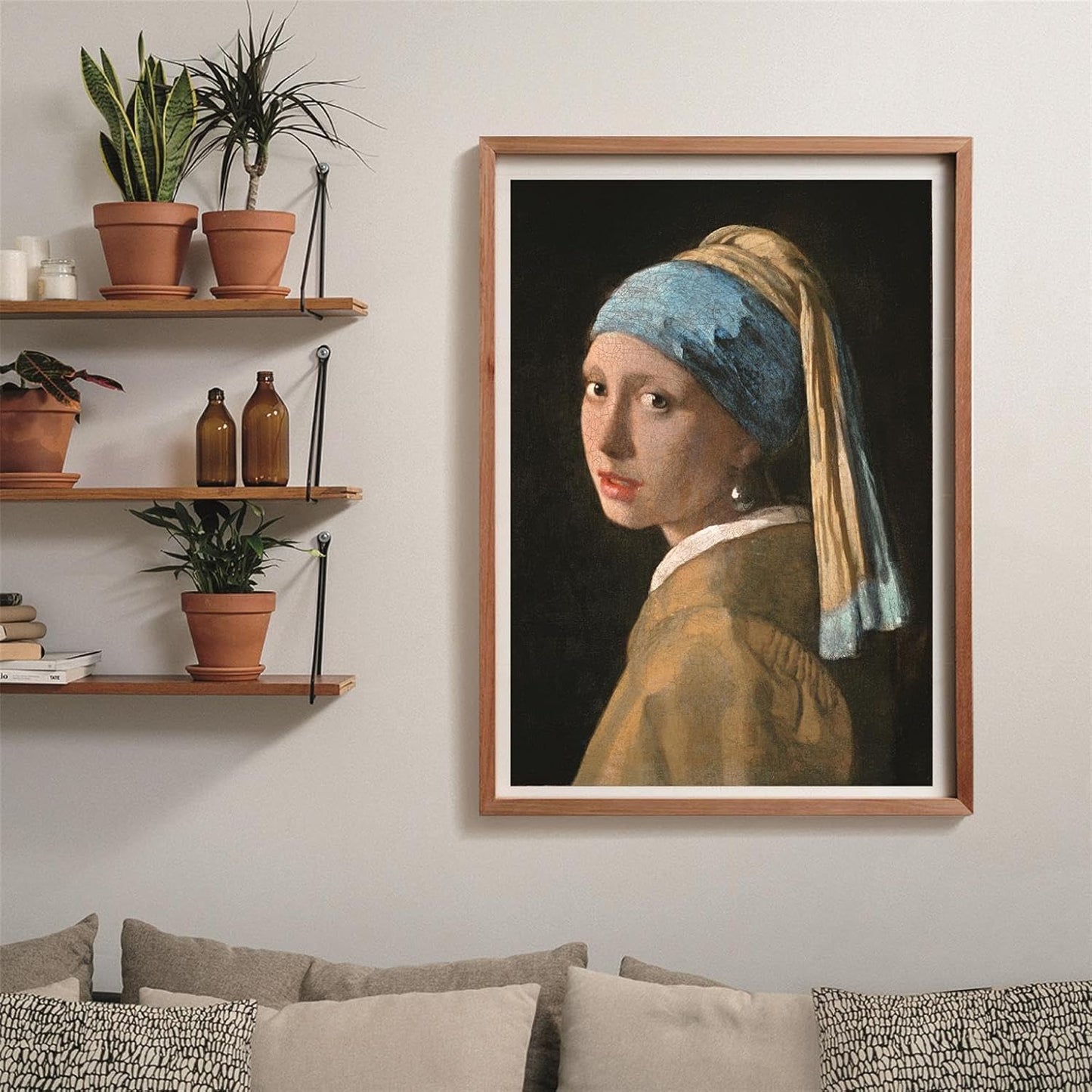 Puzzle La Joven de la Perla 1000 piezas Clementoni montado y enmarcado en madera clara sobre pared, junto a estanterías con plantas y sofá con cojines